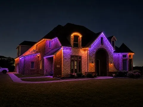 The same home at Halloween, lit in alternating purple and orange