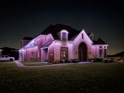 The same home in soft pink across the rooflines and the stone facade